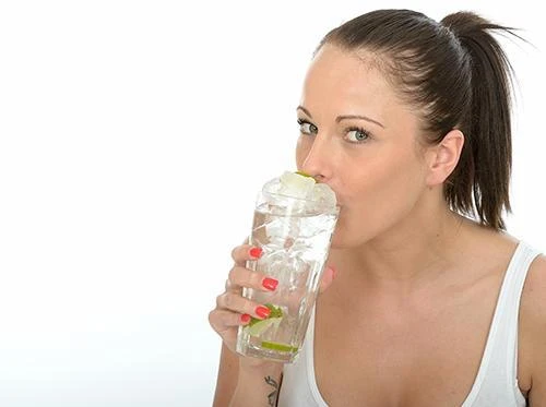 Woman sipping an iced drink instead of crunching the ice cubes