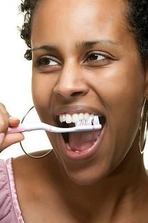 Close-up of a smile showing mild gum recession and an exposed tooth root near the gum line