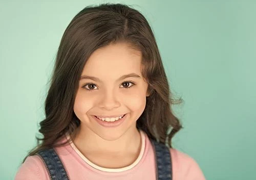 Smiling school-age girl, the age when permanent molars come in and sealants are often recommended